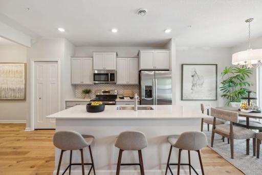 Home includes all kitchen appliances, with washer and dryer. The kitchen features grey cabinets, brushed nickel hardware and a white backsplash - Picture of Model Home