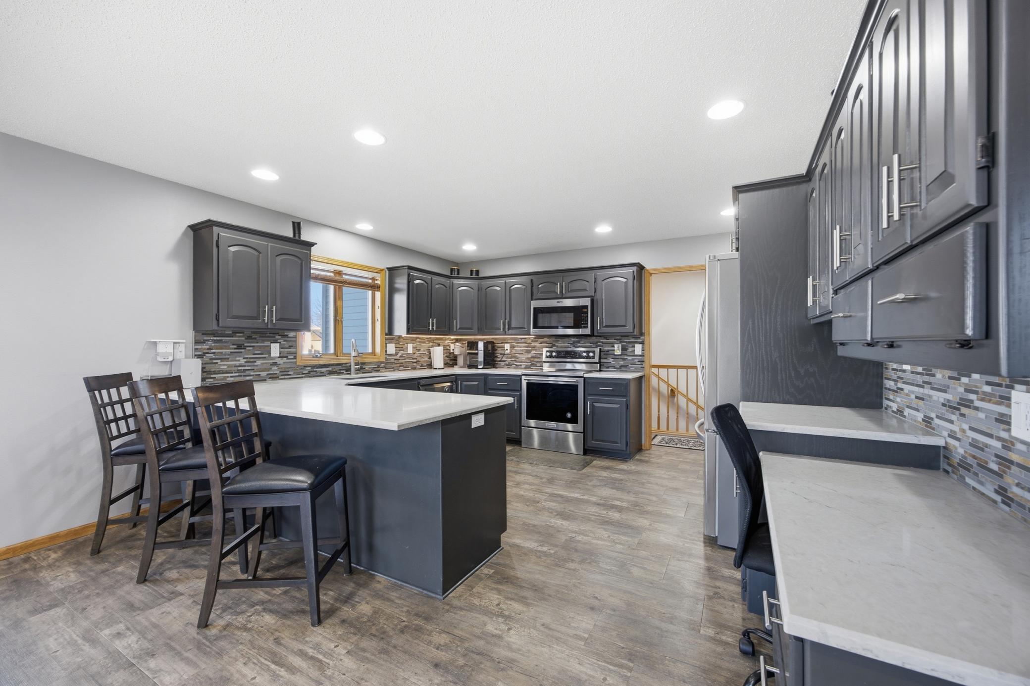 Kitchen with Quartz Counter tops, Tile Backsplash and Plenty of Cabinets