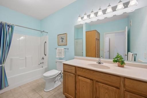 Large private bathroom featuring grab bars in the tub/shower and a linen closet.