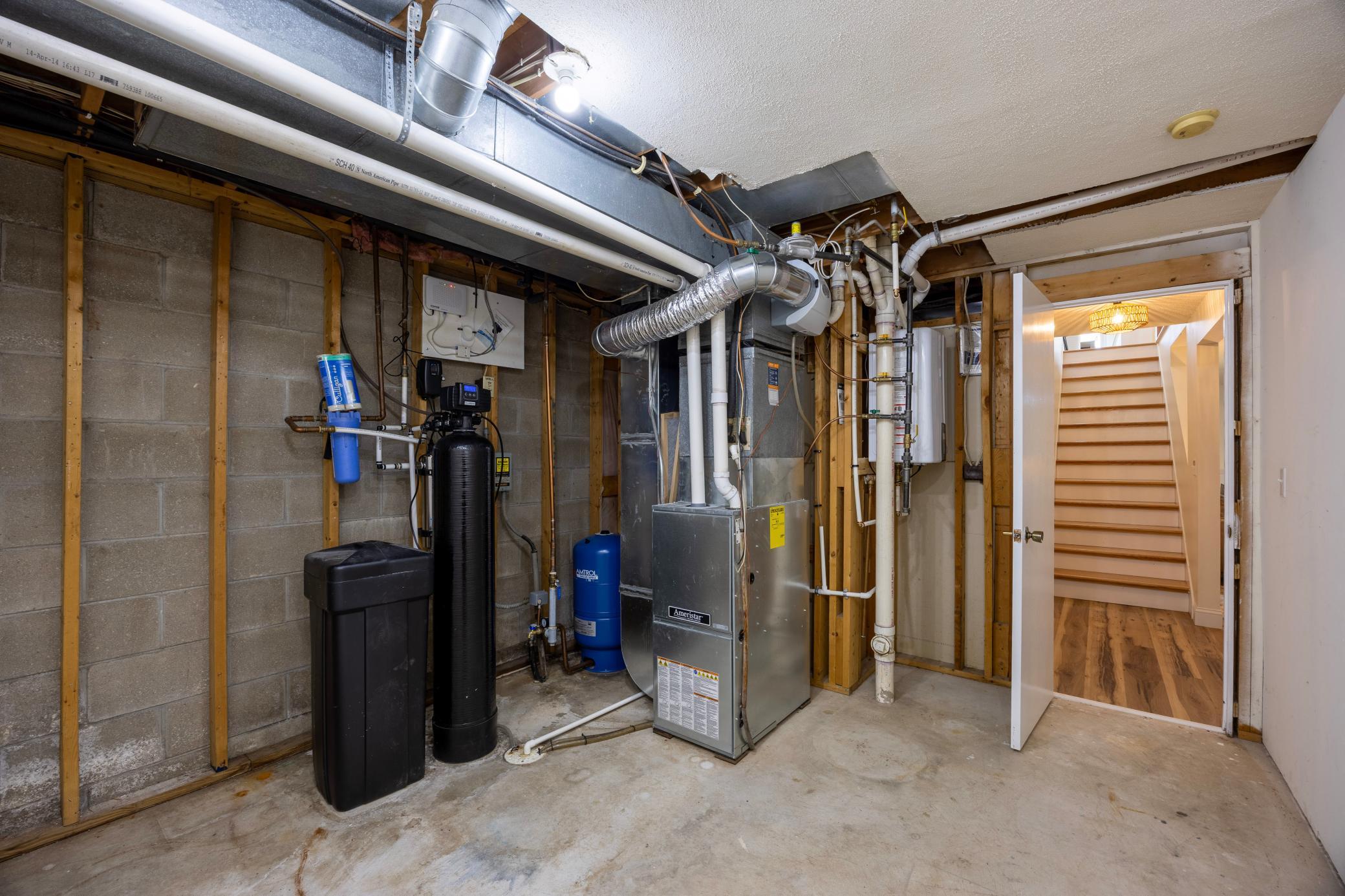 Utility room with new tankless water heater, new water softener, radon mitigation system