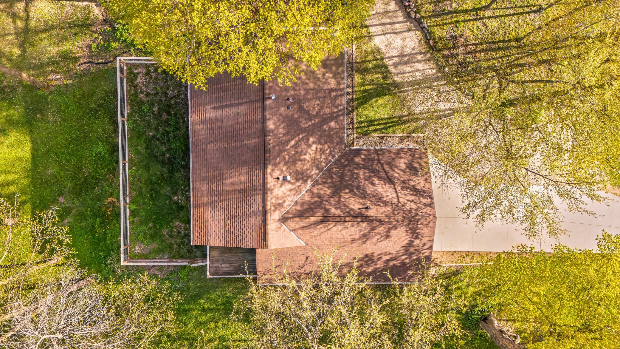 New roof, shows driveway leading to behind the home