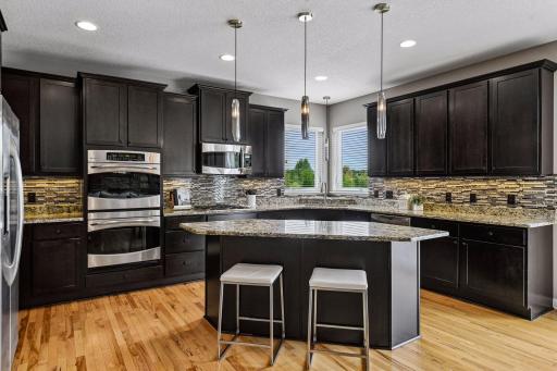 Gourmet kitchen with granite countertops, gas range, and double oven