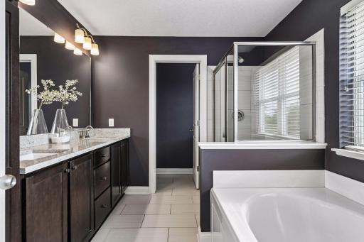 Owners bath with double sink vanity, soaking tub, tiled shower, and separate water closet.