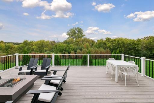 The deck offers a natural backdrop with trees framing the skyline along the rear of the property
