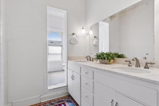 Third-level full bathroom featuring a double vanity and a well-designed layout, serving as the second full bath on this level.