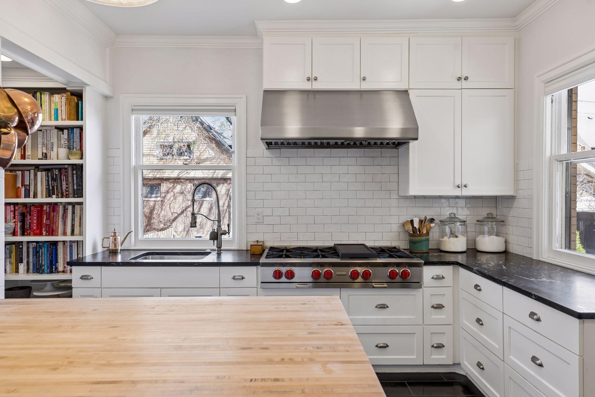 Thoughtfully updated kitchen with crisp cabinetry, a professional-grade range, and statement vent hood. Designed for both function and style, with ample prep space and beautiful natural light throughout.