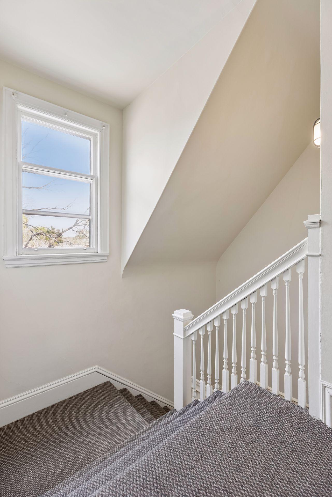 Staircase leading to the third level, offering flexibility as a private suite or integrated living space, with the potential to function as a separate unit—ideal for multi-generational living, guest quarters, or possible rental use (buyer to verify).