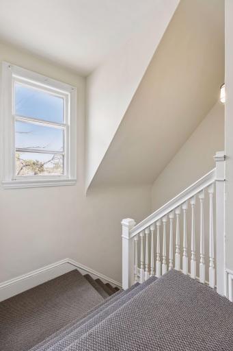 Staircase leading to the third level, offering flexibility as a private suite or integrated living space, with the potential to function as a separate unitâideal for multi-generational living, guest quarters, or possible rental use (buyer to verify).