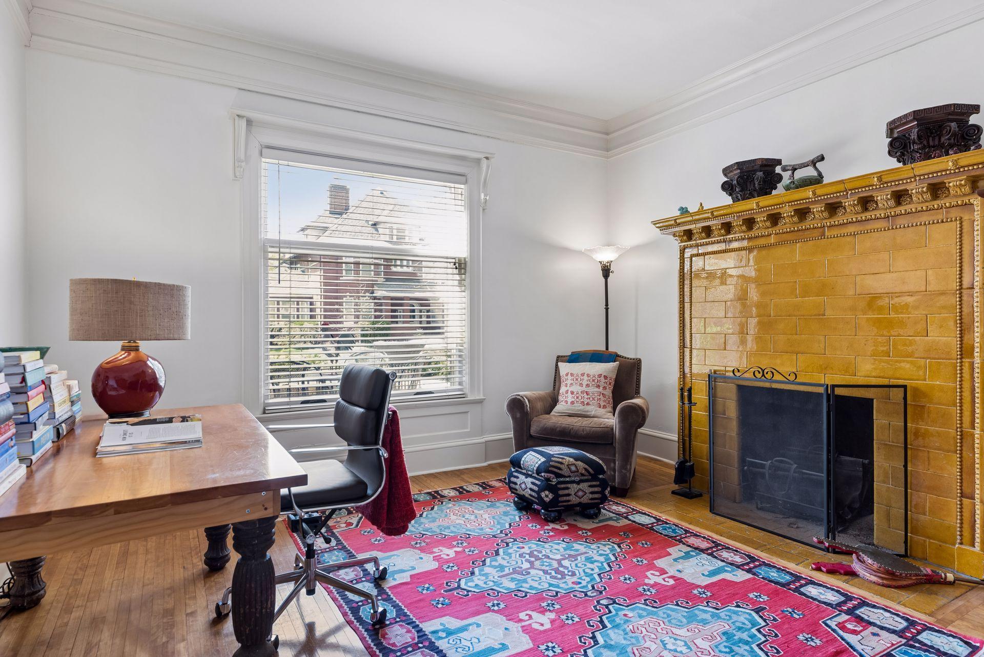 A main-level bedroom, with ceramic tile fireplace and convenient adjacent full bathroom, currently serves as a study, adding everyday flexibility.