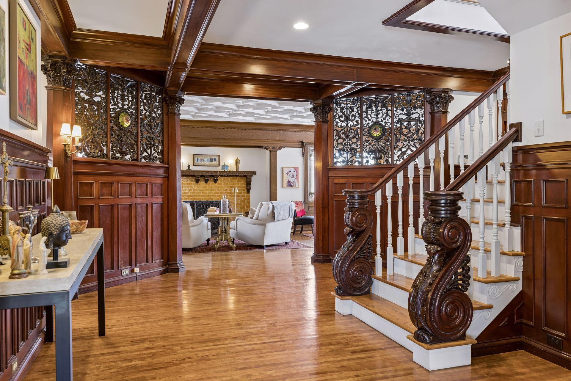 A charming entry leads into a striking statement entryway anchored by a grand staircase with carved wood details, setting the tone for everything that follows.