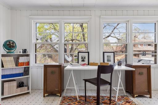 Second-level three-season porch with expansive windows, creating a bright, flexible space ideal for relaxing or a home office in the warmer months.