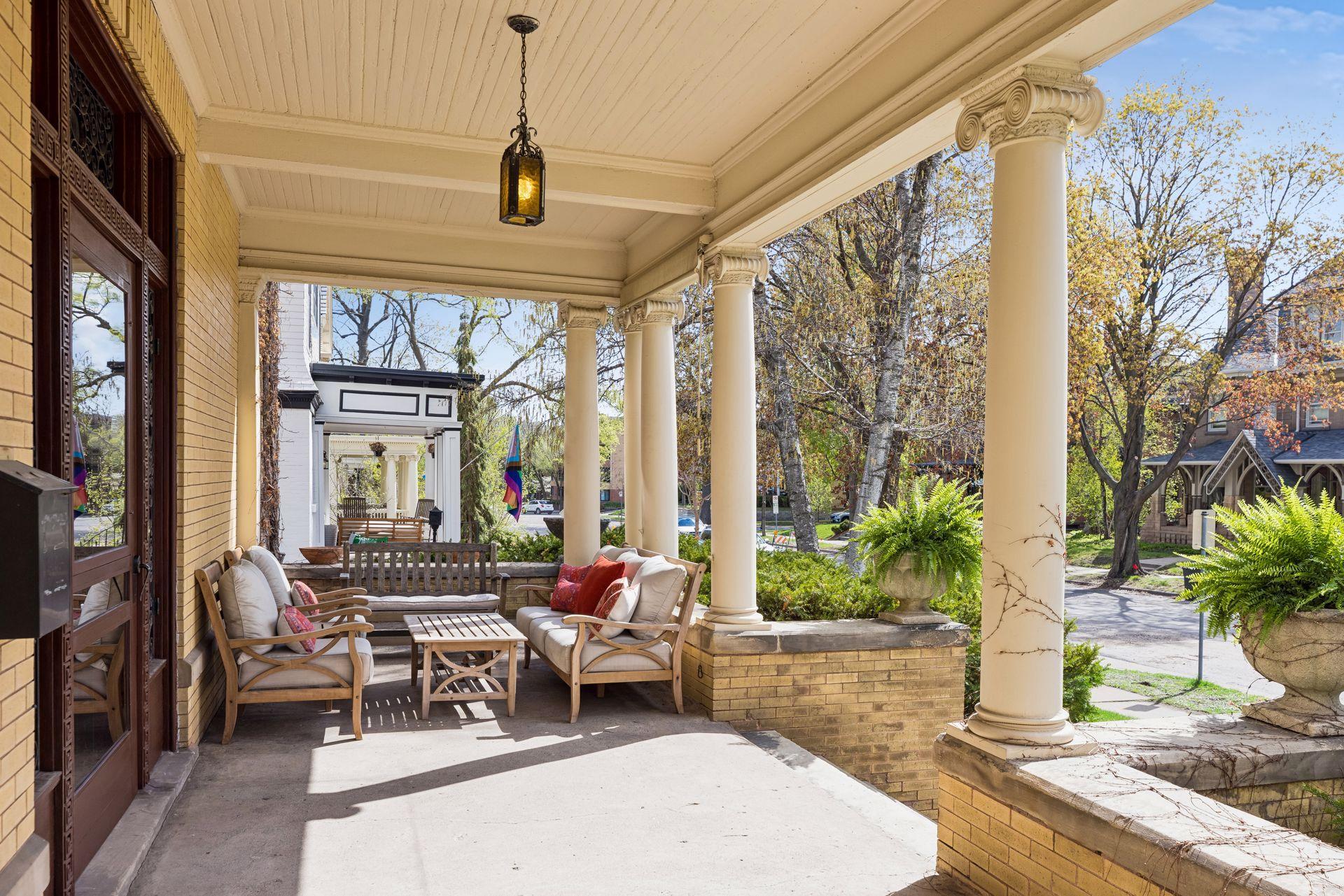 Charming covered front porch with classic columns and beadboard ceiling, offering a welcoming space to relax or entertain. Generous seating area overlooks a tree-lined street, blending timeless curb appeal with everyday comfort.
