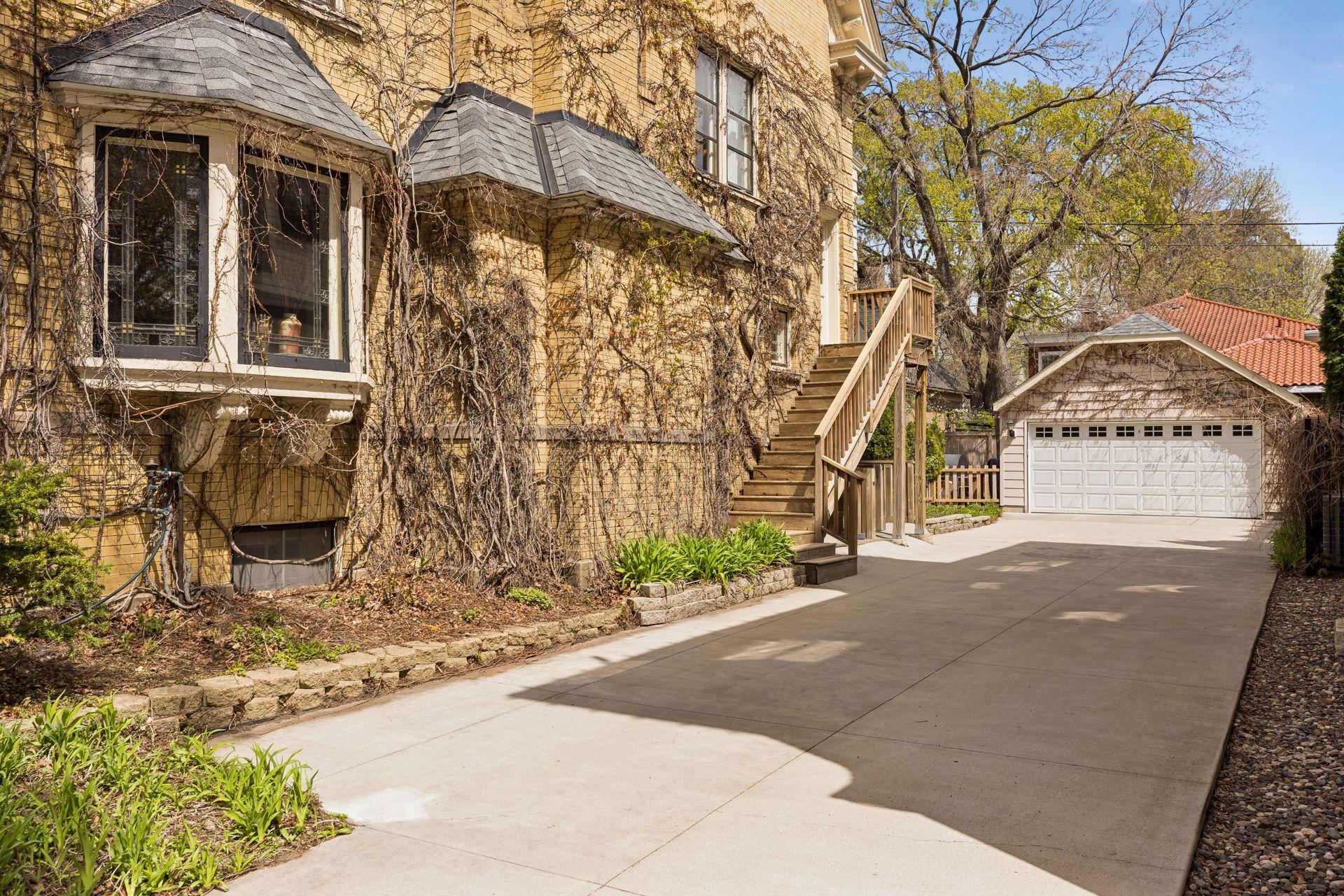 Side entrance with direct access to the third level, allowing for flexible use as a private suite or separate unit. Detached two-car garage and spacious driveway add convenience and functionality.