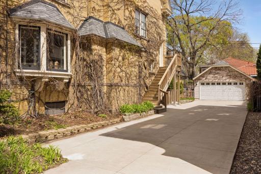 Side entrance with direct access to the third level, allowing for flexible use as a private suite or separate unit. Detached two-car garage and spacious driveway add convenience and functionality.