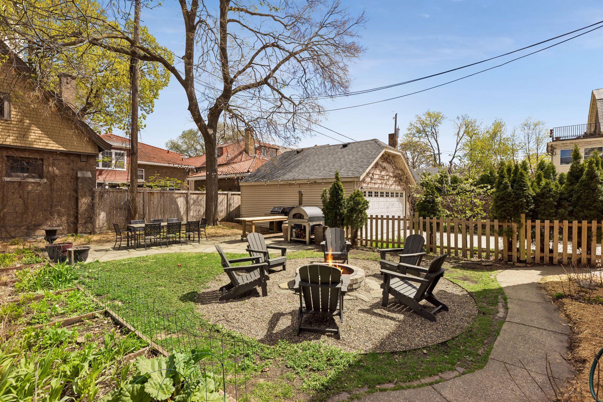 Additional view of the backyard showcasing the detached two-car garage, patio area, and multiple spaces for outdoor dining and gathering.