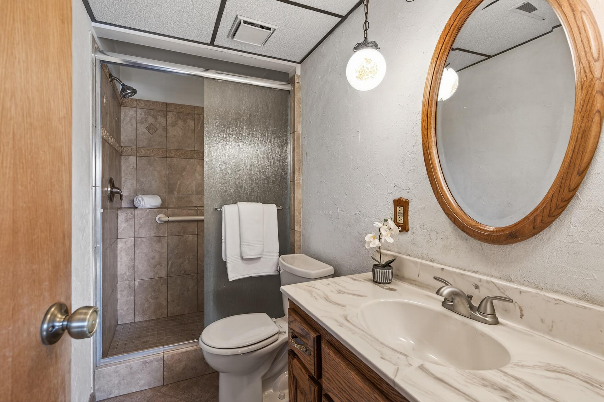 Lower level bathroom with updated tile shower & glass door.