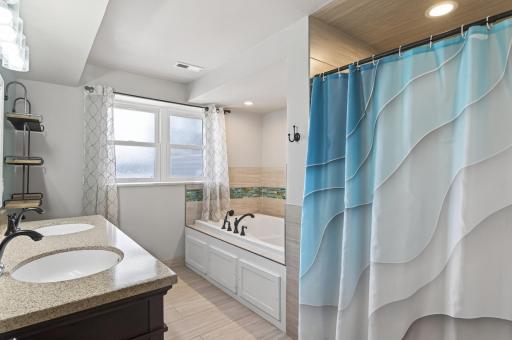 This lower level bathroom is an oasis with tiled floors and shower and a massive bathtub