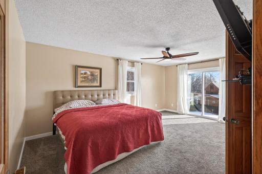 Large upper level primary bedroom with patio doors leading to a future deck