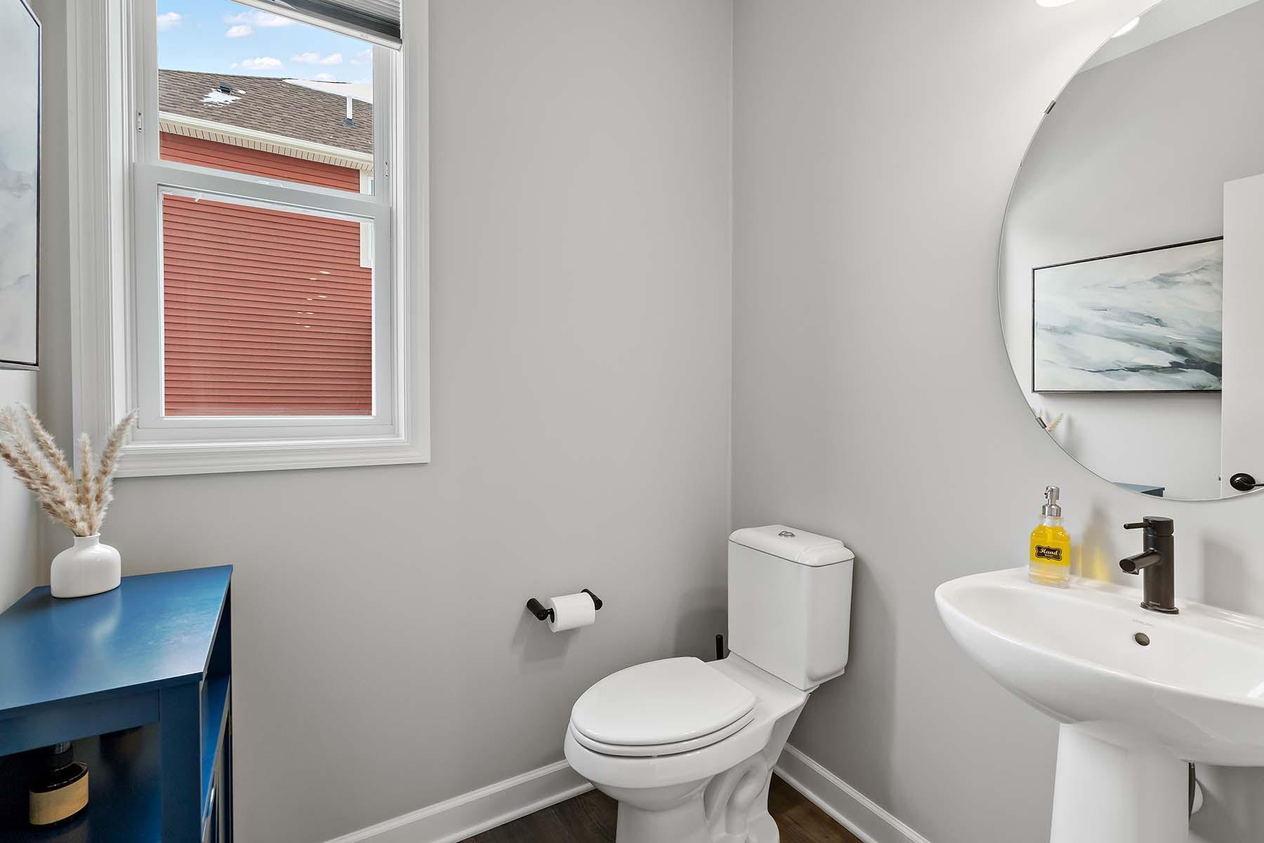 This main level powder room features an elegant pedestal sink that anchors the space with timeless charm. Perfect for guests, it combines refined finishes with a clean, welcoming layout.