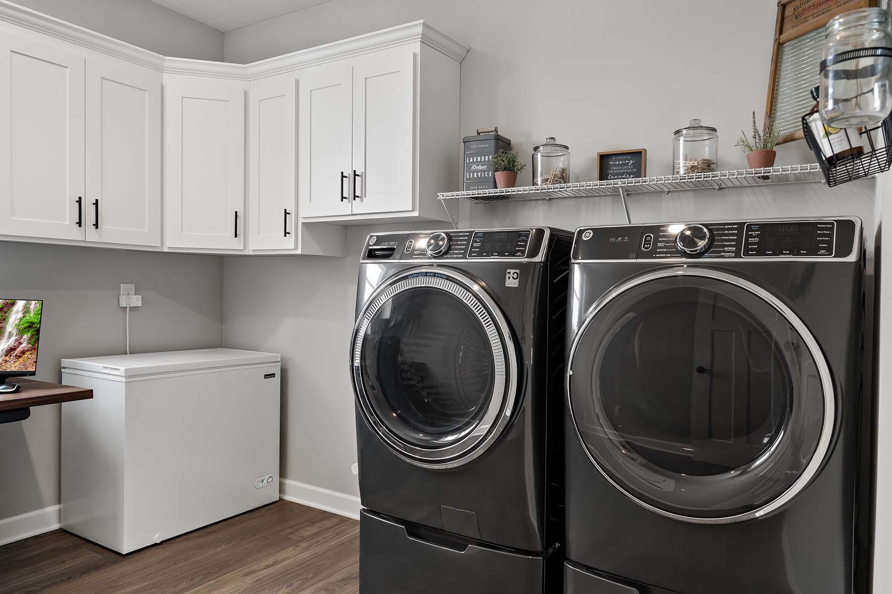 The main-floor laundry room is designed for both convenience and functionality, featuring a hookup for a utility sink and built-in cabinetry for added storage and organization. Washer and Dryer are Wi-Fi enabled.