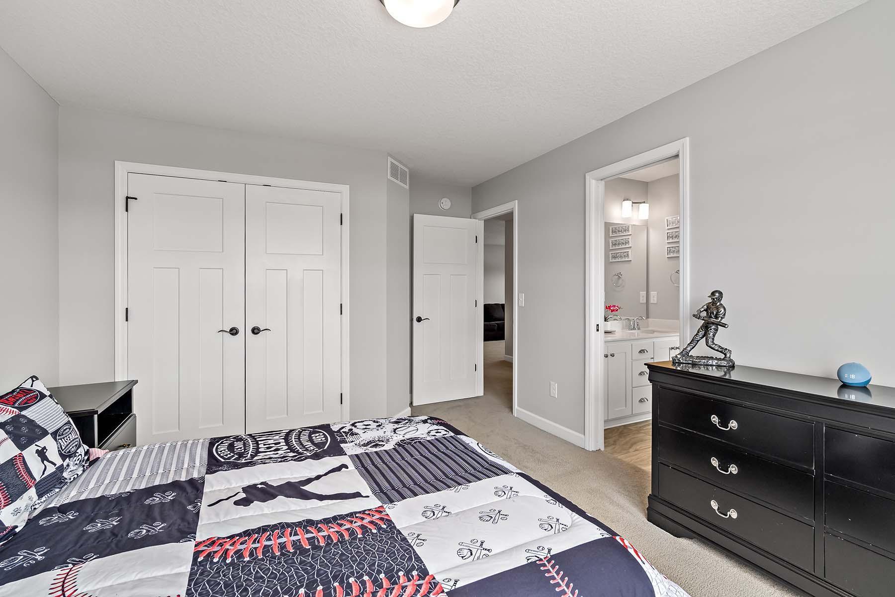 This bedroom pairs comfort with functionality, offering a roomy closet and direct access to the shared bathroom.