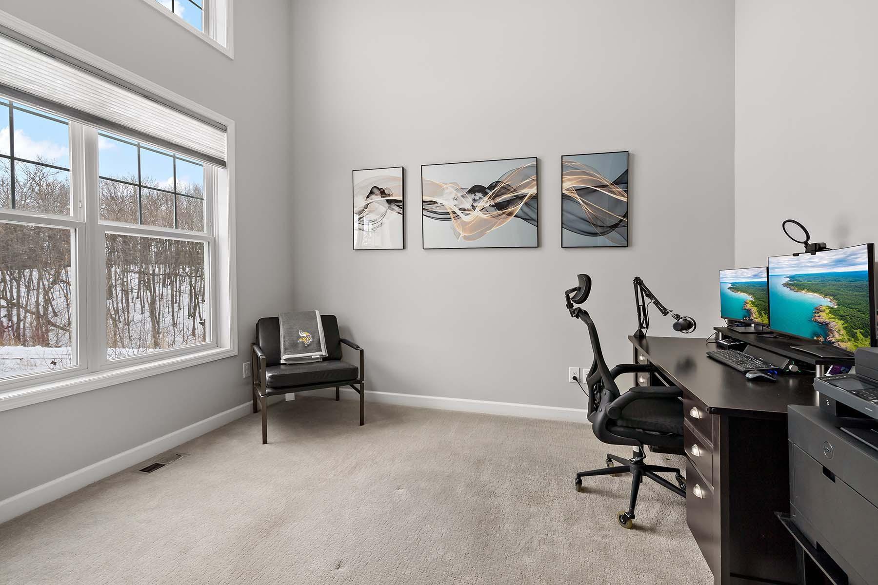 The dedicated office makes a striking impression with its soaring two-story ceilings, elegant French doors, and expansive windows fill the space with natural light while offering views of the front yard. Upper windows have remote controlled blinds.
