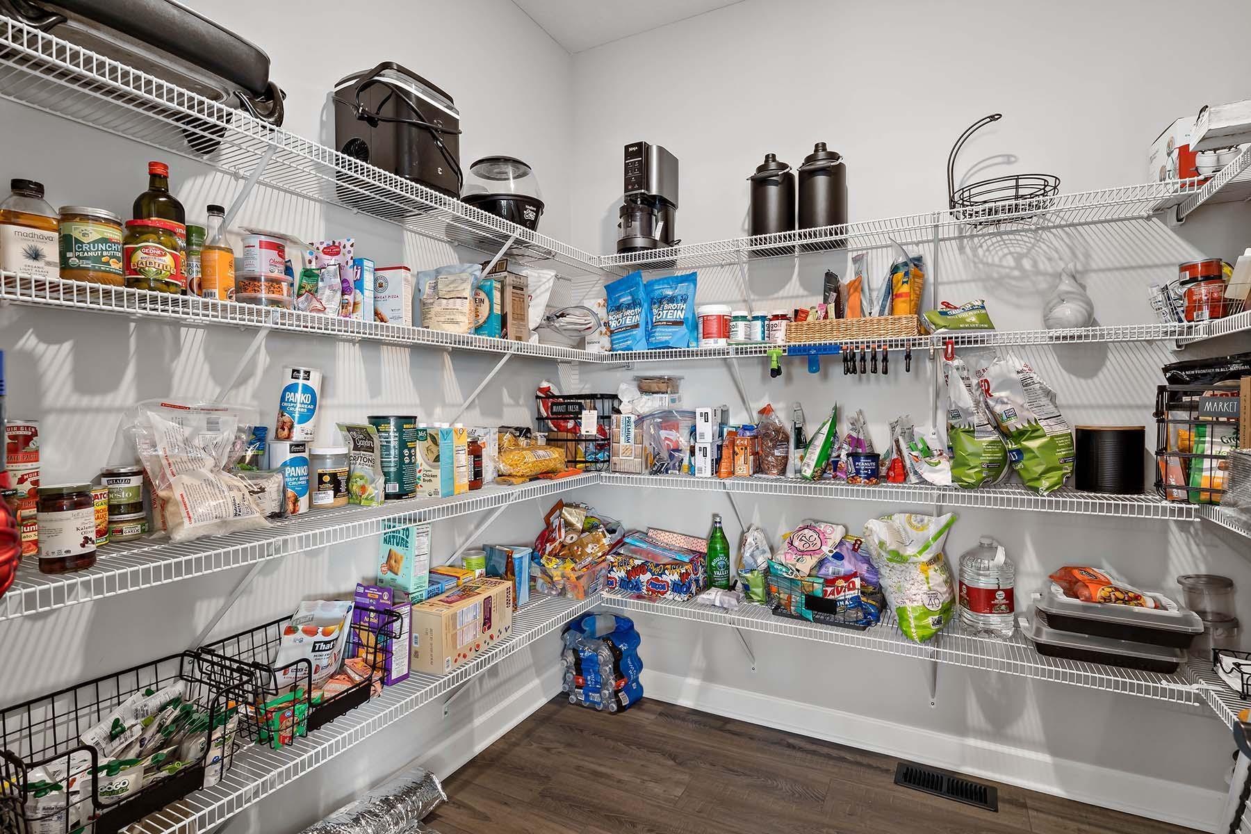 Maximize your kitchen's potential with this walk-in pantry, featuring shelving designed to keep groceries, small appliances, and essentials organized & within easy reach.