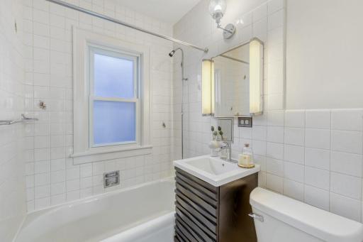 Main floor full bathroom is a blend of retro charm with recent updates including new vinyl flooring and a new vanity.