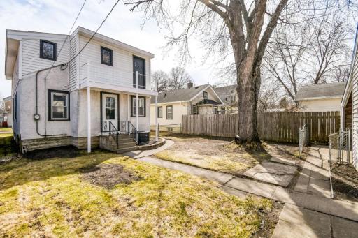 The backyard is fully enclosed with a combination of fencing and offers ample space for a garden, patio, or outdoor entertaining area.