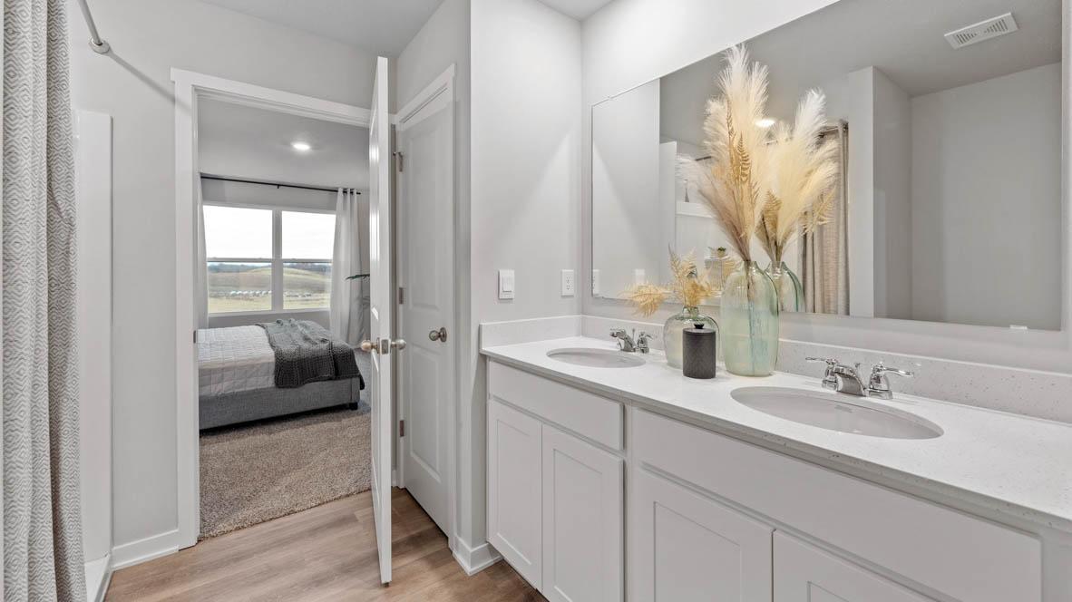 Large primary bedroom with double sinks. Photos are of similar staged home. Colors and options may vary. Ask Sales Agent for details.