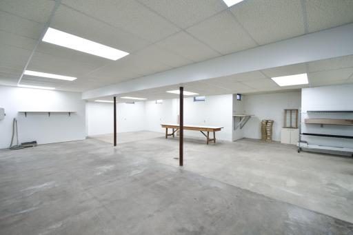 The downstairs lower level is a blank slate; white paint on the concrete block walls makes it look nice and fresh, drop ceiling keeps your options open with working with electrical or plumbing lines.
