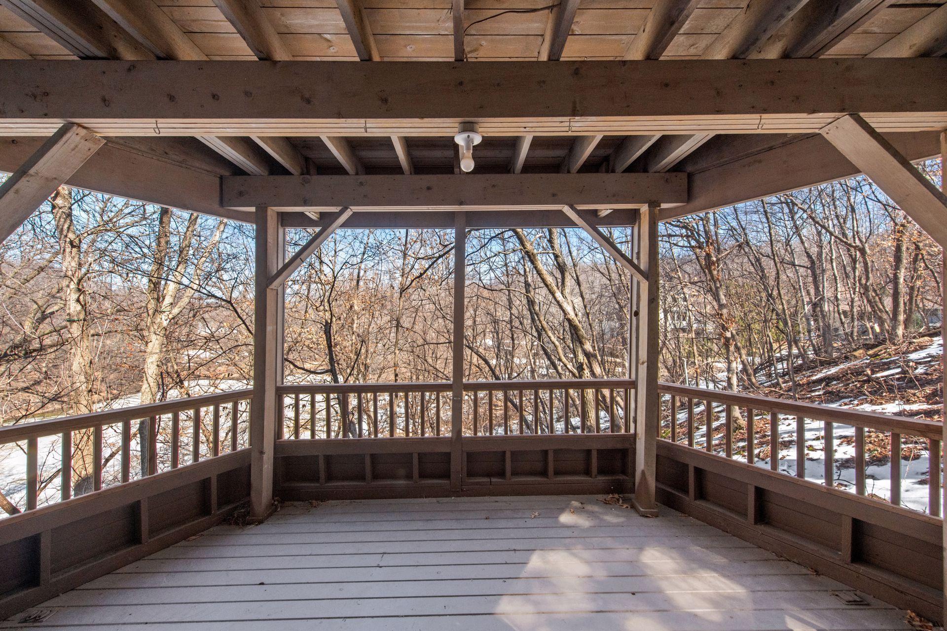 Screened porch, with panoramic views of the wooded backyard and pond.