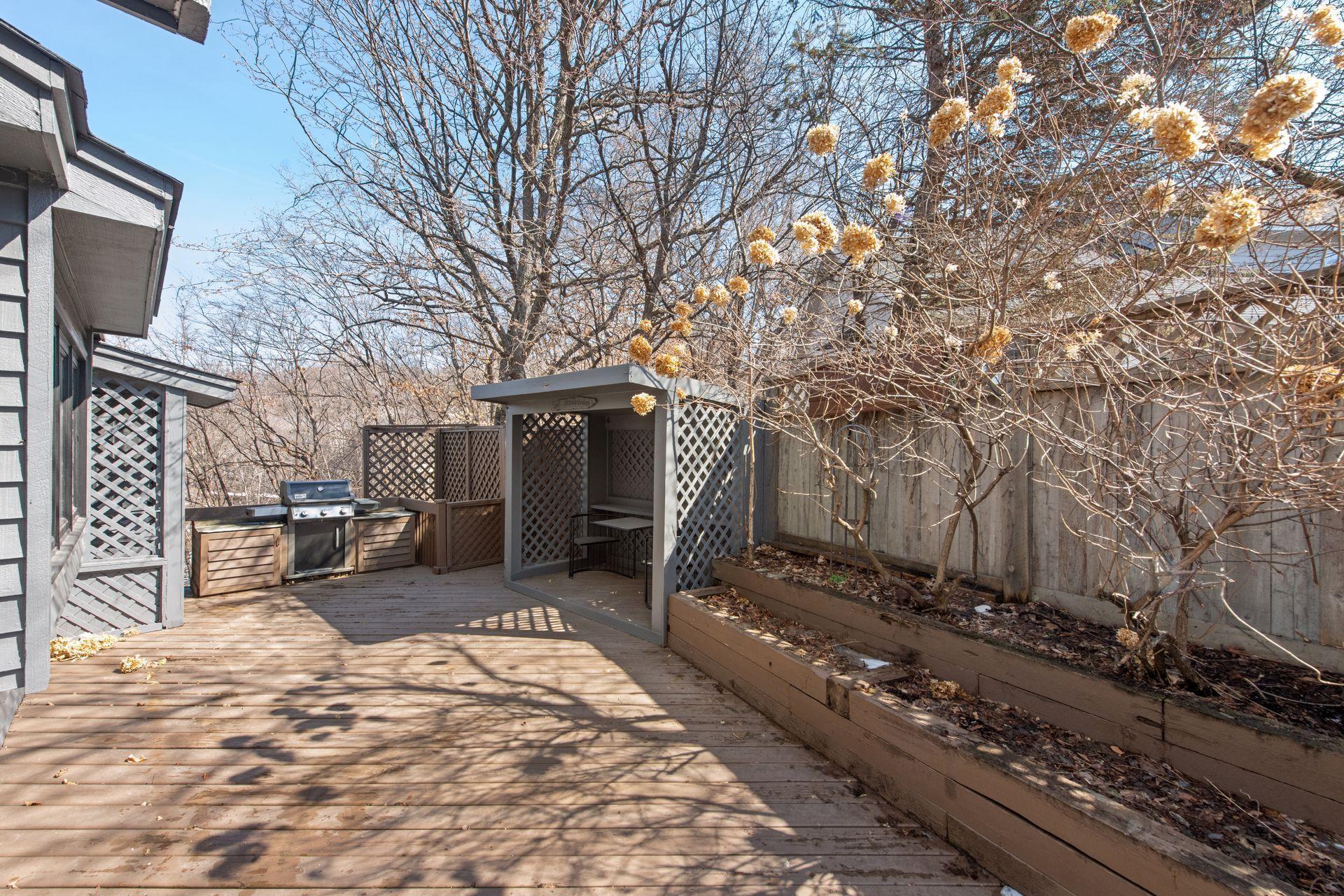 Side deck, with grill and access to the kitchen and informal dining through the three-season porch.