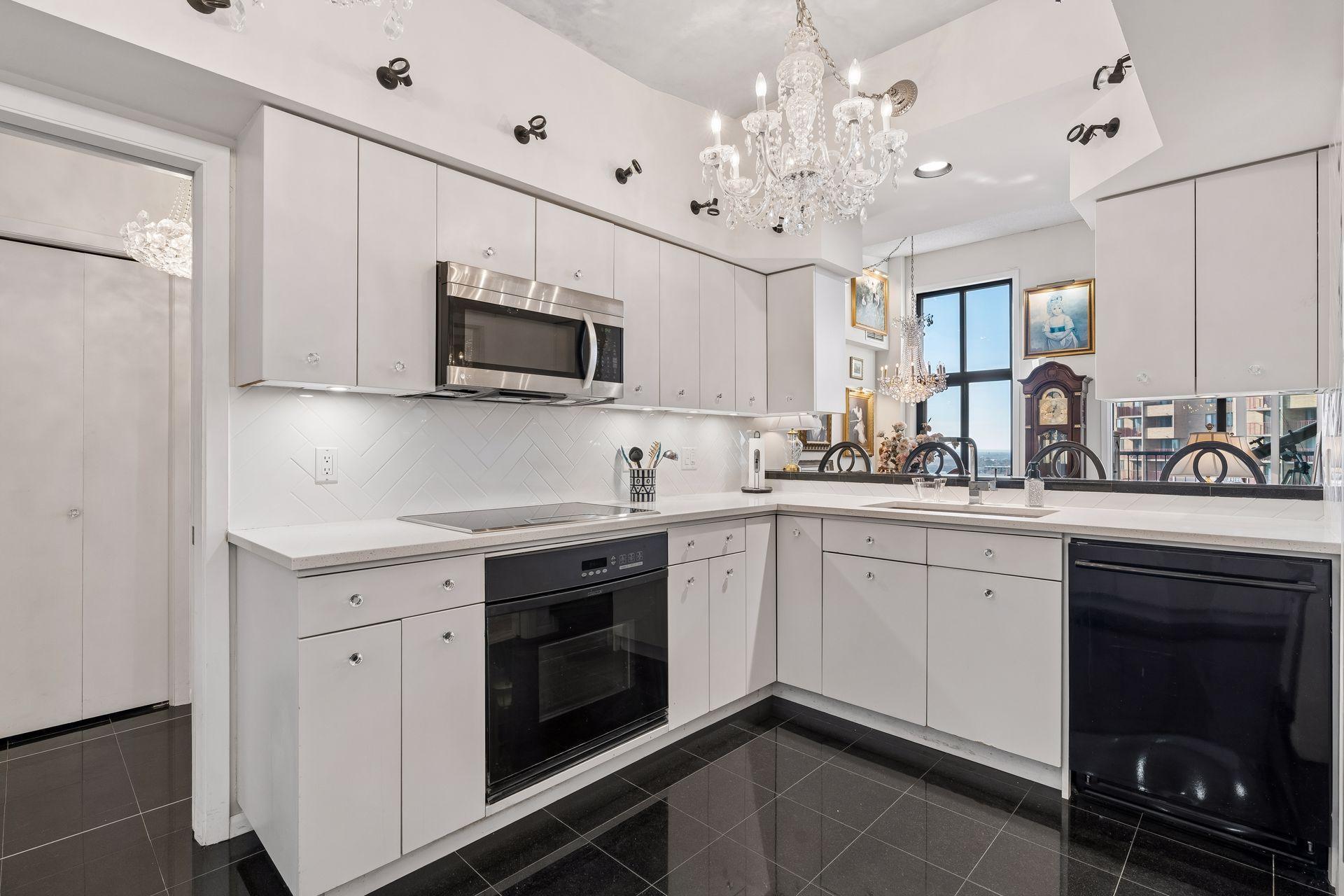 Thermador cooktop and Dacor oven in the well appointed kitchen with an elegant tile backsplash and stone countertops throughout the kitchen.