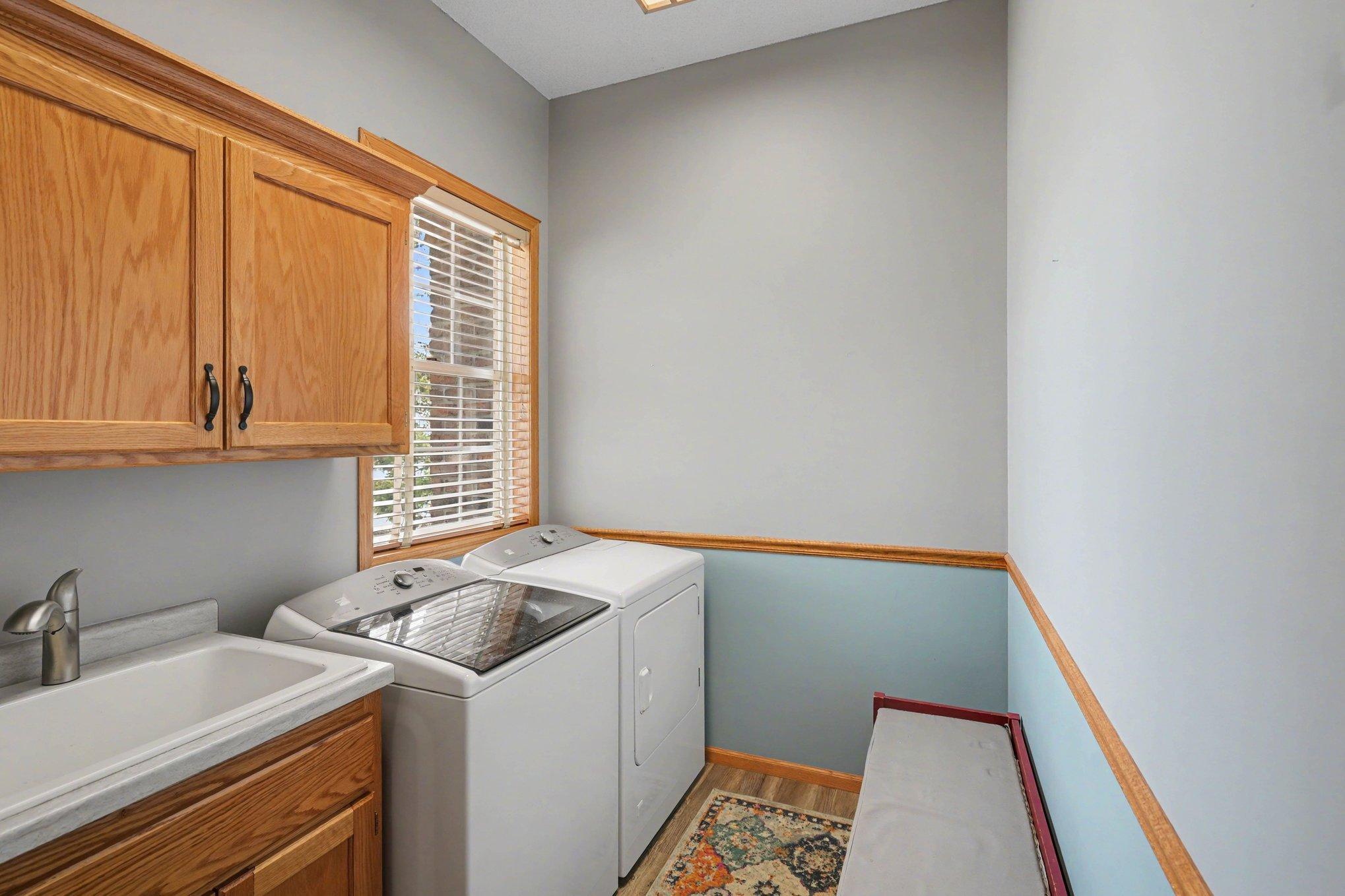 Convenient main floor laundry with sink and storage.