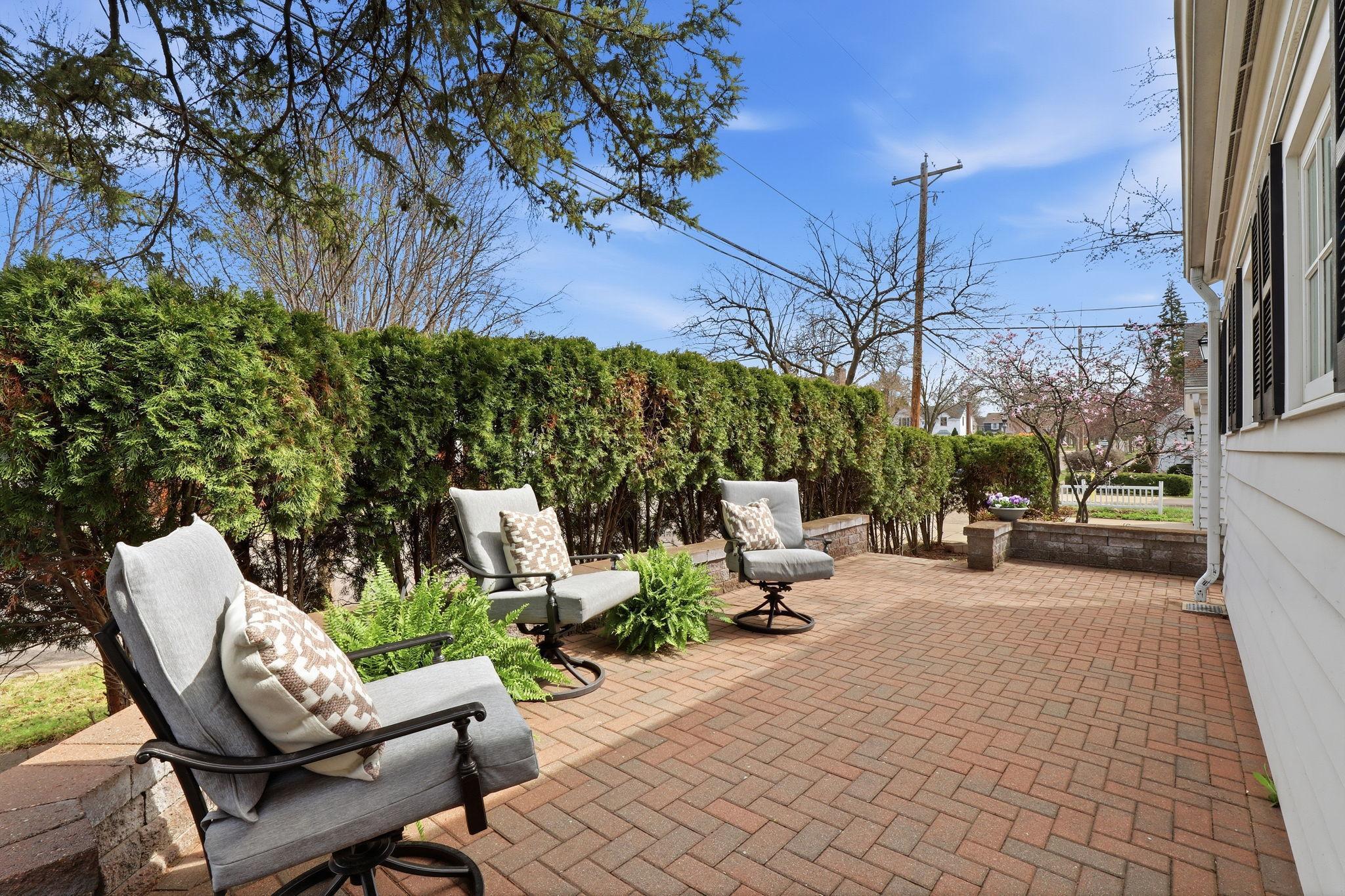 Brick patio surrounded by mature arbor vitae