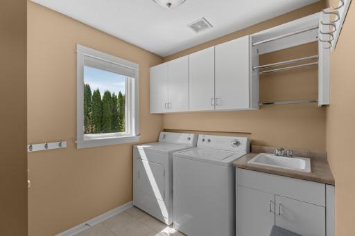 Main level laundry room with sink and rack