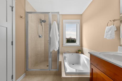 Private primary bathroom features a soaking tub and tiled shower.