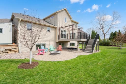 Backyard features a deck, pergola and landscaped fire pit