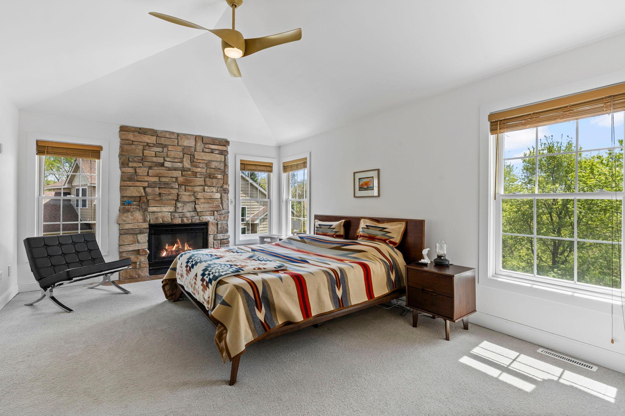Primary bedroom with vaulted ceilings and gas fireplace