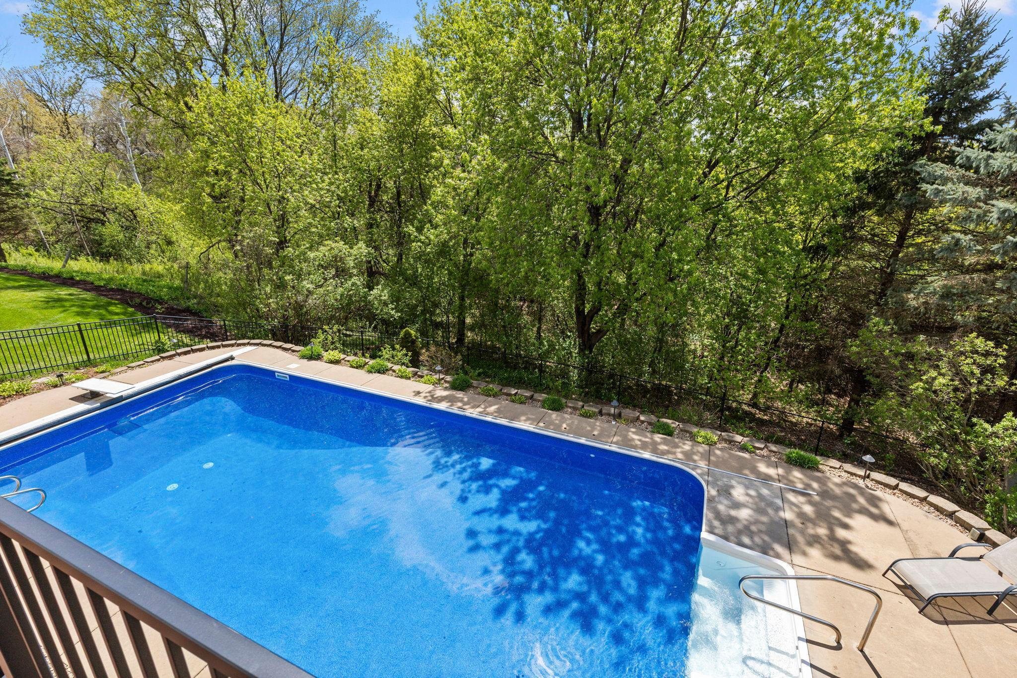 Pool surrounded by private wooded area