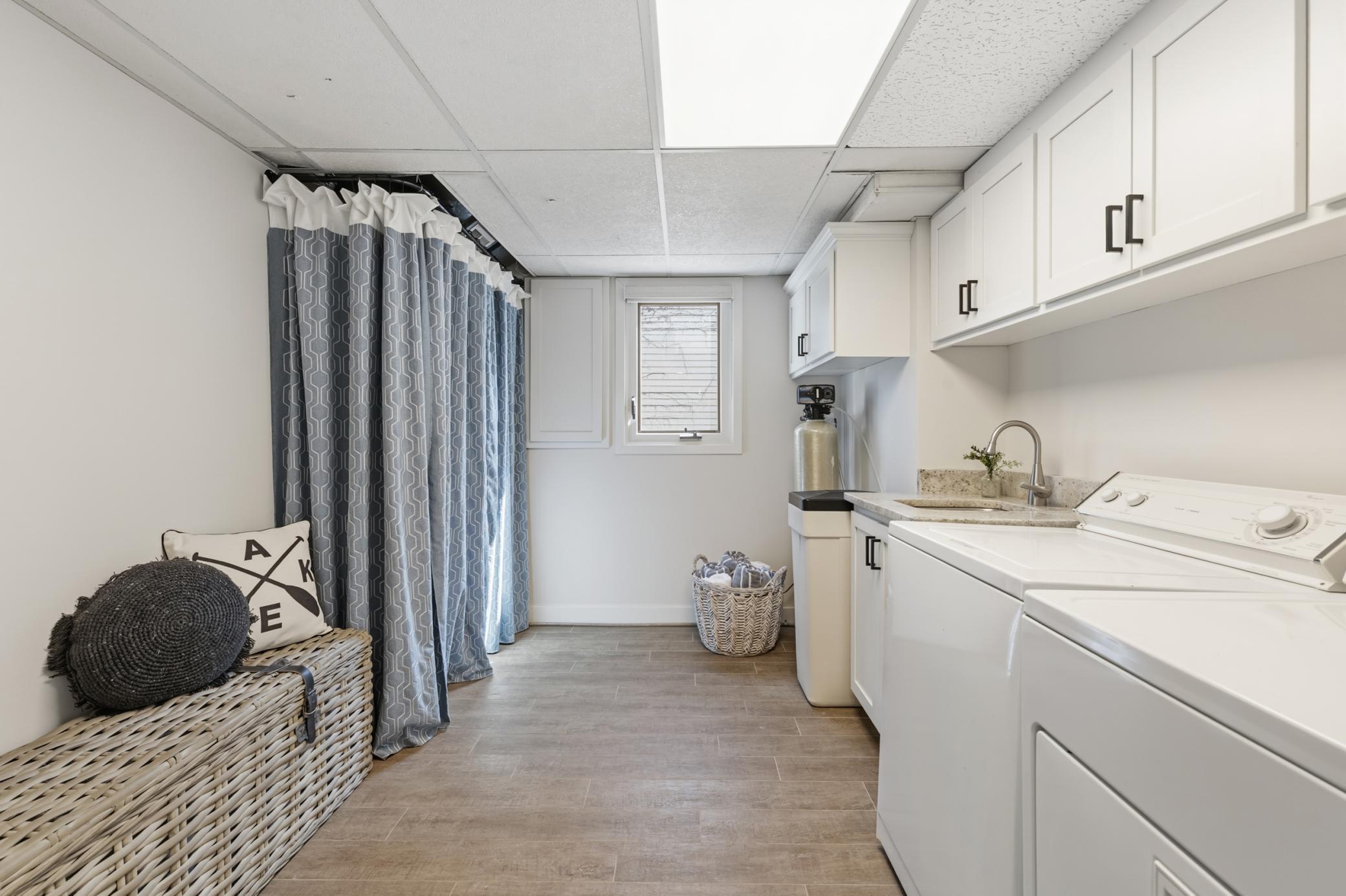 Laundry Room features enameled cabinets with/ granite countertop and undercount quartz composite sink, and ceramic tile flooring. Open and bright!