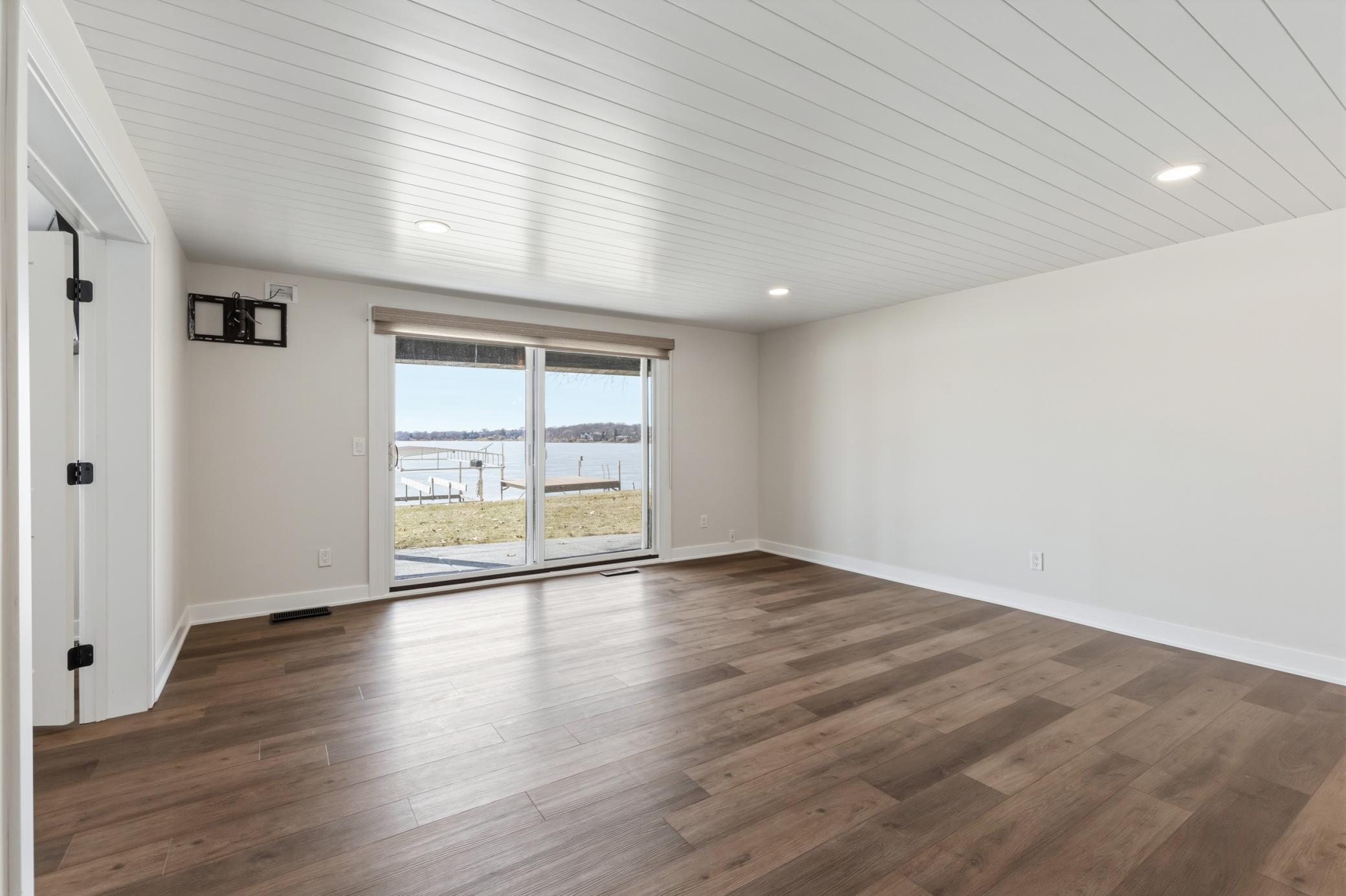 Full glass patio door with access to the covered patio, shared green space and lakeshore