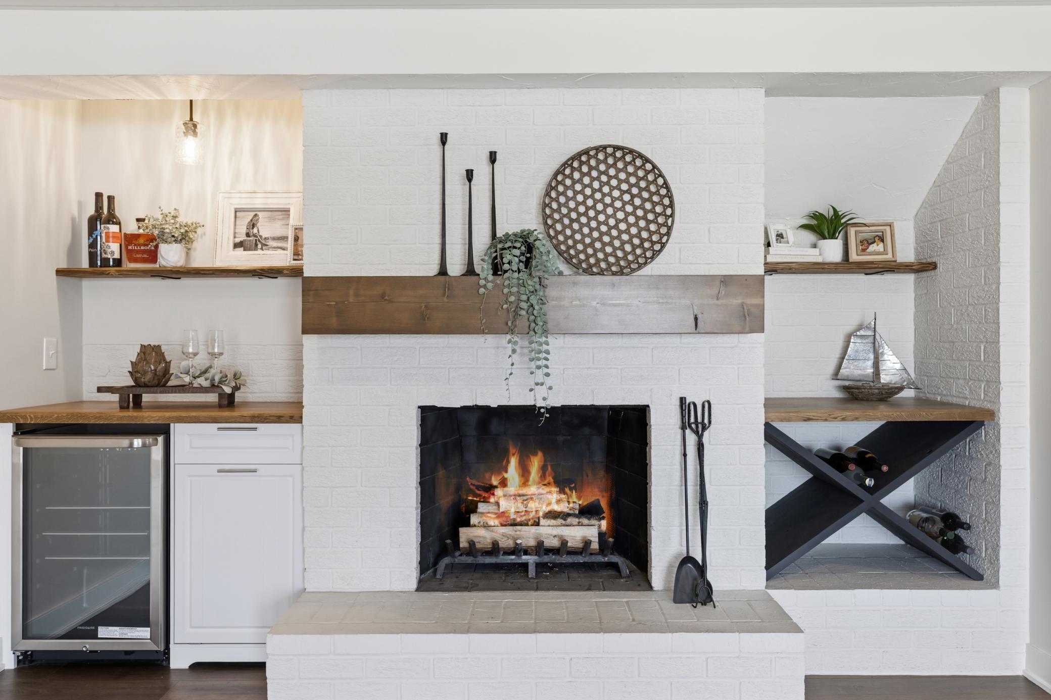 Wood burning fireplace w/ brick surround and raised hearth. Built-in entertainment cabinetry features beverage refrigerator, trash pull-out, Wine bottle or blanket display, butcher block tops and display shelves!