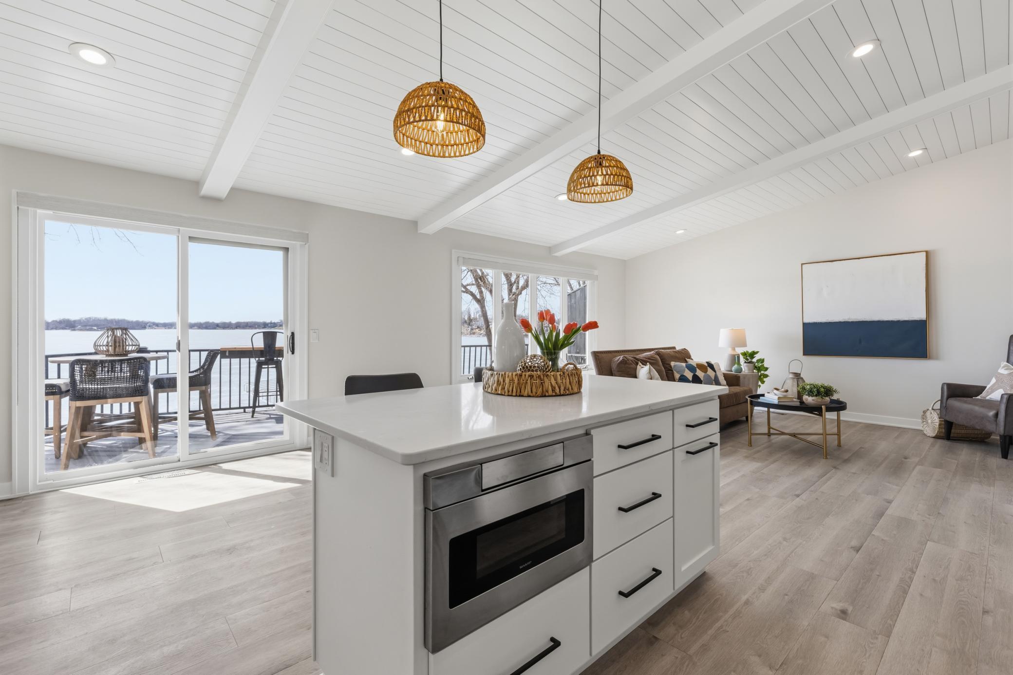 Full glass patio door with access to the deck. Vaulted shiplap paneled ceilings with decorative beams. Luxury vinyl plank flooring throughout.