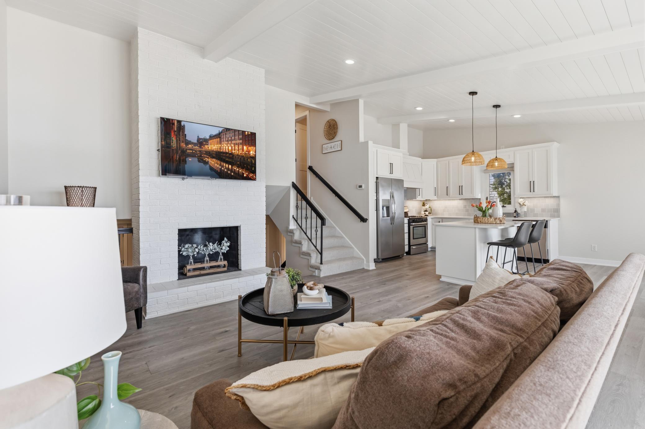 Wood burning fireplace with brick surround and hearth. Kitchen and Living Room are both open.