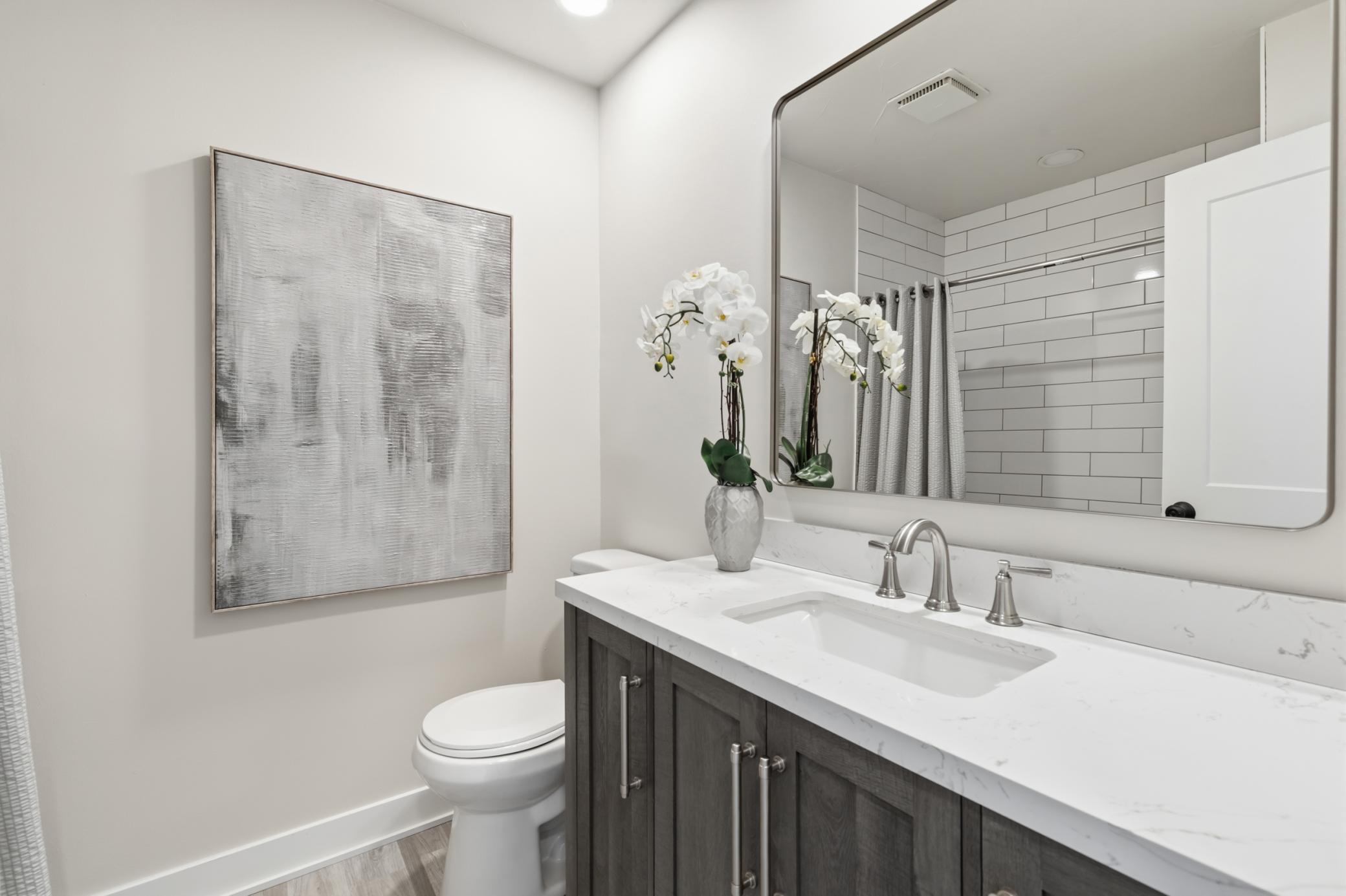 Full Bathroom was remodeled in 2024. Modern vanity cabinet with quartz top, tub offers subway tile surround and luxury vinyl plank flooring.