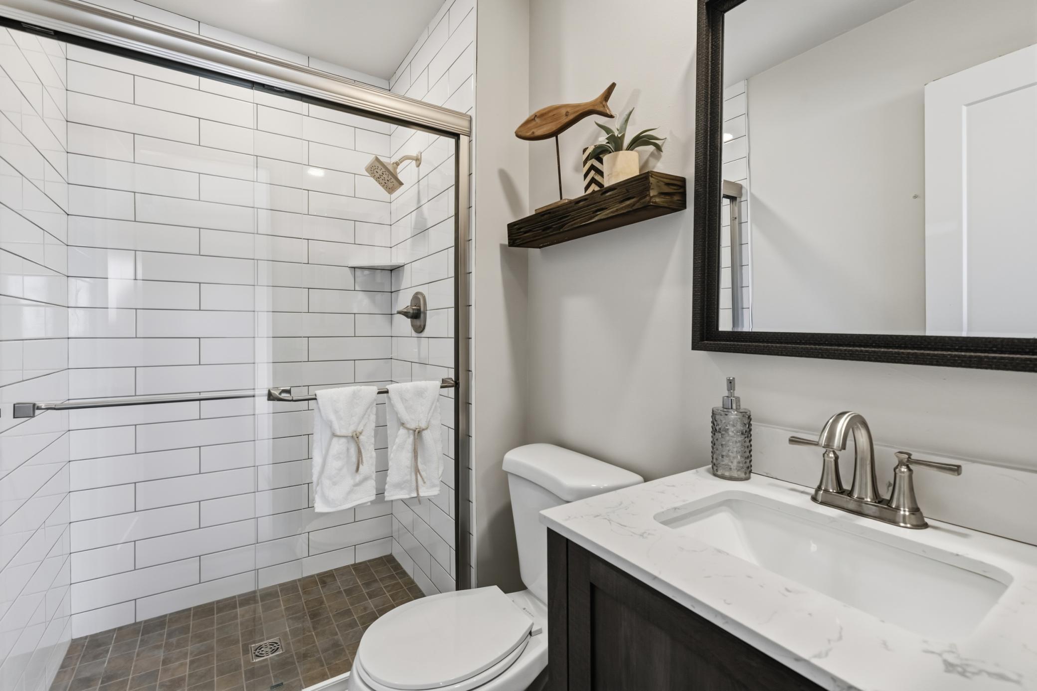Master 3/4 bathroom was remodeled in 2024! Modern vanity cabinet w/ quartz countertop and luxury vinyl plank flooring. Shower features tile surround and glass doors.