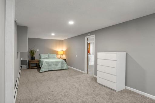 This level also includes a spacious fourth bedroom with an egress window and generous closet space, plus access to a partially finished laundry and storage area.