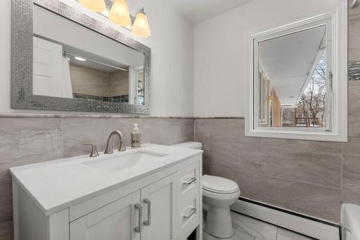 A well-appointed shared full bathroom with a single vanity and tub/shower combo is conveniently located nearby main level bedrooms.